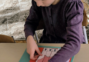 Dziewczynka układa obrazek Polski