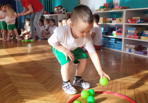 Chłopiec odkłada zieloną piłkę