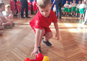 Chłopiec odkłada czerwoną piłkę