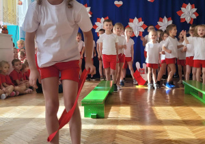 Dziewczynka przechodzi przez szarfę