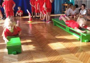 Dzieci przeciągają się po ławeczkach