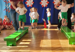 Maluszki przechodzą po ławeczkach