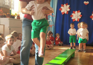 Dziewczynka zeskakuje z ławeczki