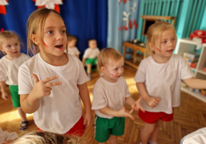 Dzieci śpiewają piosenkę z pokazywaniem