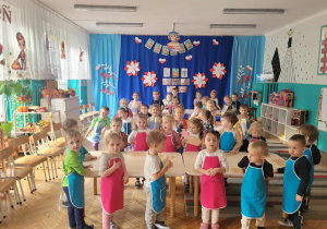 Dzieci ustawione wokół stołów