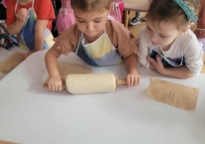 Dziewczynka zawinęła ciasto na wałek