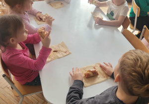 Dzieci przy stoliku jedza rogale