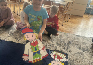 Chlopiec pokazuje sylwetę krakowiaka