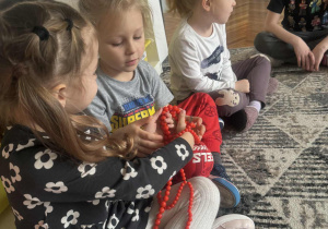 Dzieci przekazują sobie czerwone korale