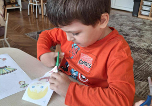 Chłopiec wycina przy stole