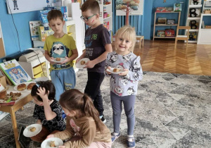 Dzieci z rogalami na talerzach