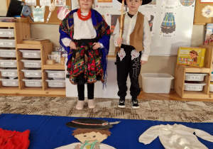 Dzieci w strojach góralskich z podobizna górala z kartonu