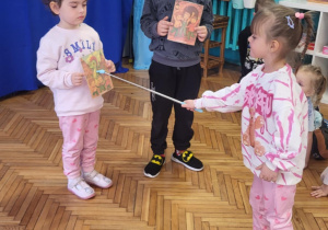 Dziewczynka wskazuje zdjęcie Bazyliszka z odczarowanymi dziećmi