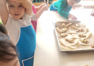 Dzieci kładą rogale na brytfannę