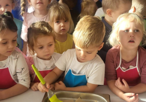 Chłopiec smaruje rogale jajkiem