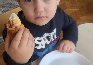 Chłopiec trzyma rogala w ręku