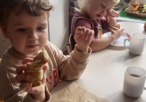 Dzieci przy stole jedzą rogale