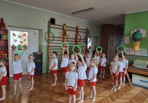 Grupa dzieci stowi z kołami w górze