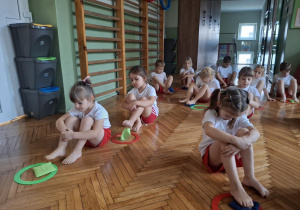 Dzieci stopą wrzucają woreczek do koła