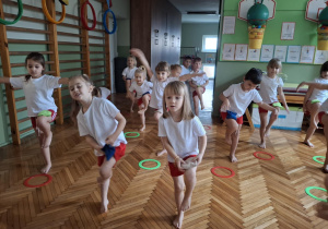 Dzieci kładą woreczek na nodze