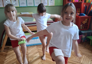 Dziewczynka stoi i podniesioną nodą w górze