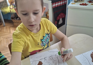 Chłopiec wykleja gawrę misia