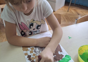 Dziewczynka maluje krzaki na zielono