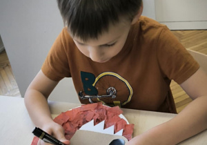 Chłopiec dorysowuje oczy wilkowi