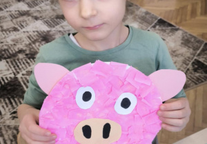 Dziewczynka z pracą plastyczną świnki