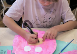 Dziewczynka dorysowuje nos śwince