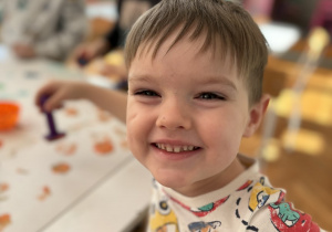 Chłopiec uśmiecha sie do aparatu