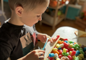 Chłopiec przykleja kreatywne chrupki