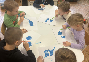 Dzieci dmuchają na niebieską farbę