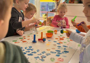 Dzieci bawią się farbami przy stoliku