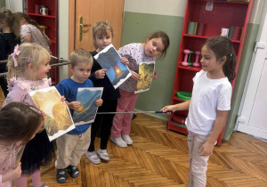 Dziewczynka wskazuje na ilustracji złotą krople