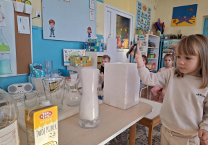 Dziewczynka szczypcami bierze lód