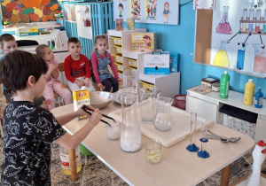 Chłopiec nabiera lód szczypcami