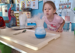 Dziewczynka dmucha na dym