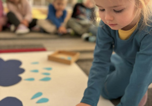 Dziewczynka dokłada krople deszczu