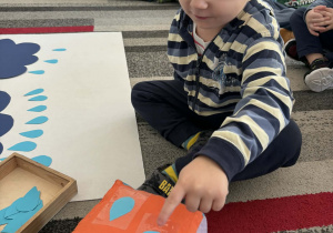 Chłopiec przelicza krople deszczu na kostce