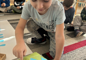 Chłopiec przelicza krople deszczu na kostce