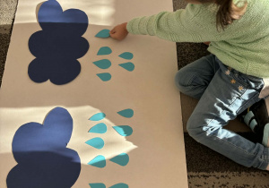 Dziewczynka doklada jedną kroplę deszczu