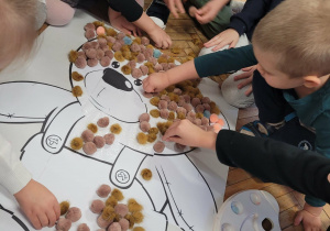 Dzieci przyklejają brązowe puszki