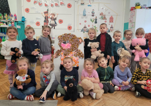 Dzieci z grupy drugiej z sylweta pluszowego misia wykonaną za pomocą puszków