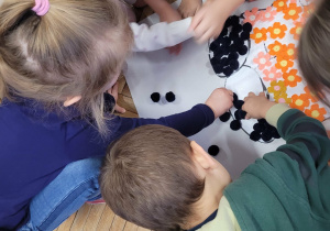 Dzieci przyklejają czarne puszki