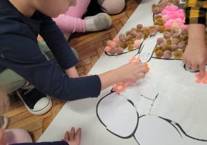 Dzieci przyklejają różowe puszki