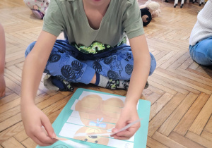 Chłopiec układa puzzle