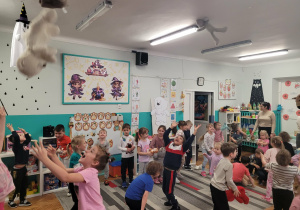 Dzieci podrzucają misie do góry