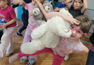 Dziewczynka tanczy z białym misiem