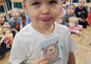 Chłopiec pokazuje minę logopedyczną